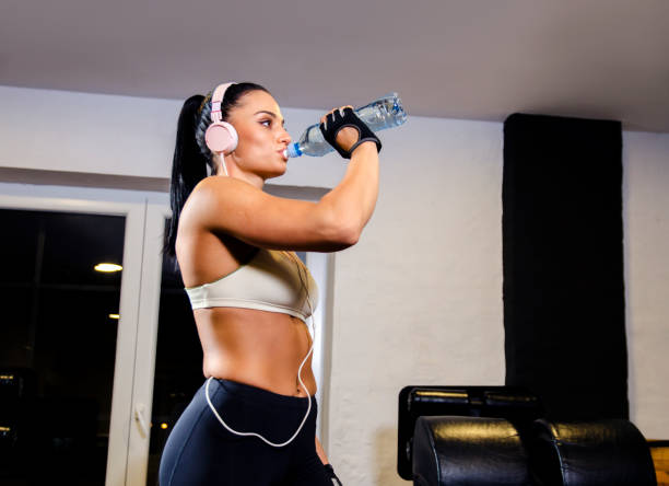 istock Beautiful woman, drinking water in gym 1071935744