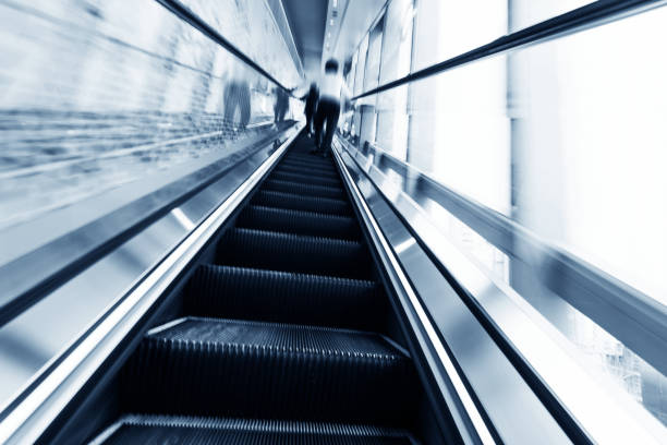 istock Rear view of people standing on escalator 1071948520