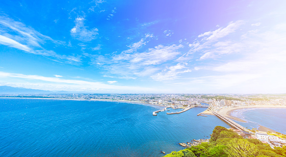 Asia travel concept -  the famous travel place, enoshima island and urban skyline aerial panoramic view under dramatic blue sky and beautiful ocean in kamakura, Japan.
