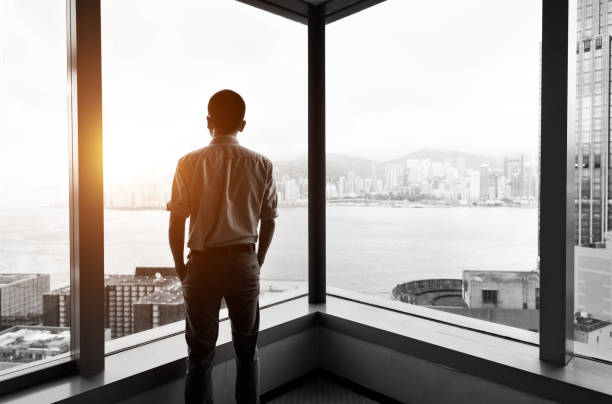 istock Businessman looking at city through office window 1071954160