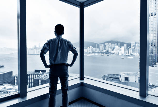 istock Businessman looking at city through office window 1071954286