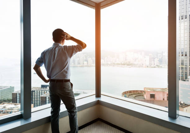 istock Businessman looking through the window and thinking 1071954370