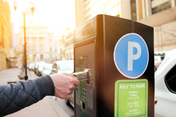 man is paying his parking using credit card at  parking pay station terminal stock photo