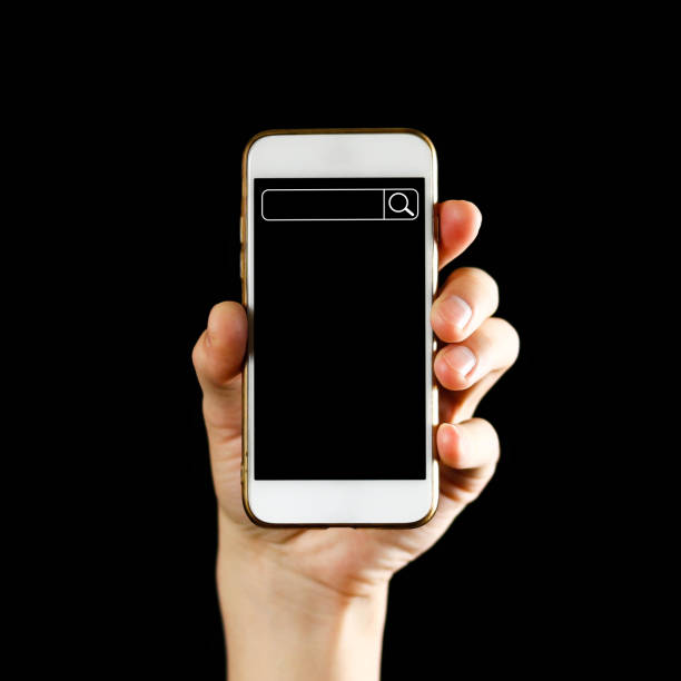 istock Search bar on the phone screen. Hand holding white smartphone with blank black screen. Close up. Isolated on black background 1071976624