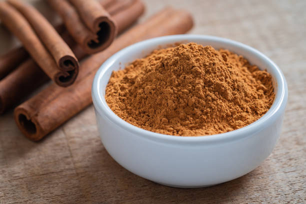 istock Cinnamon powder and cinnamon sticks on wooden table 1071998486