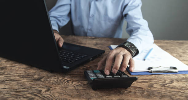 istock Businessman using calculator and working on laptop. Business concept 1072014056