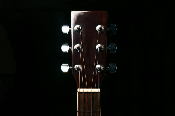 istock Acoustic guitar neck on black background 1072014192