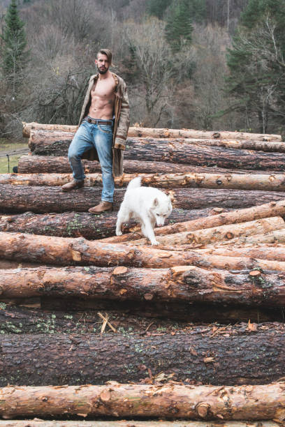 istock Young man and dog on logs in the forest 1072021740