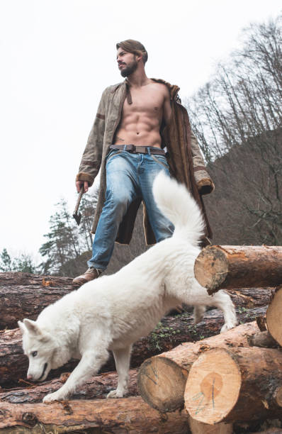istock Young man and dog on logs in the forest 1072021770