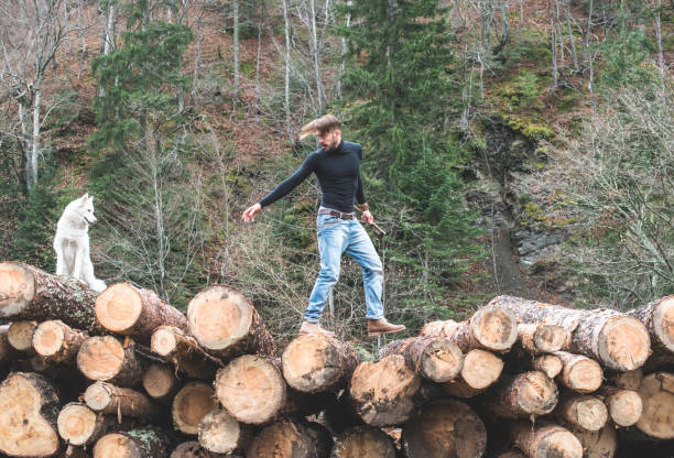 istock Young man and dog on logs in the forest 1072021920