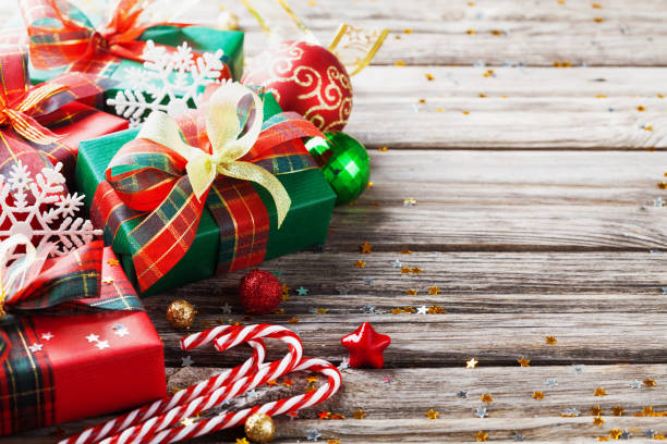 istock Christmas gift boxes with holiday decorations on wooden background. 1072023572