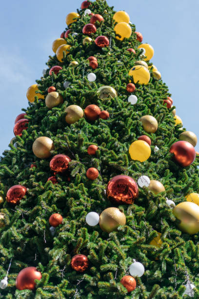istock Christmas tree decorated with red, yellow and silver ornaments with bright sky background. 1072027800