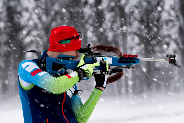 istock Side View of Young Male Biathlon Competitor Practicing Target Shooting in Snowstorm 1072034150