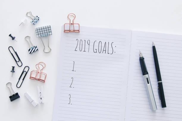 istock Top view 2019 goals list with notebook over white wooden desk. 1072042680