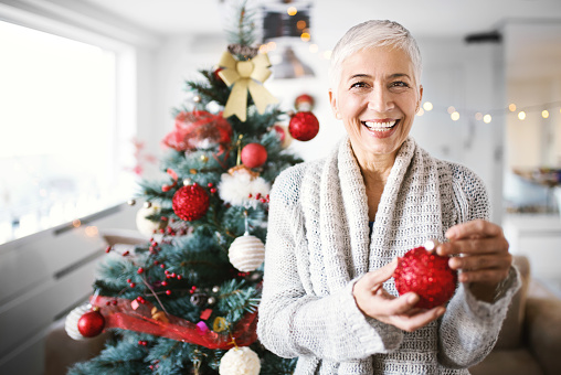 Christmas photo of blonde woman with beautiful smile wearing Santa Claus costume. Snow Maiden cheerfully smiling, posing on green studio background. Xmas time. Copy space.