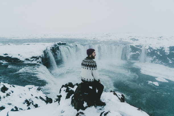 man kijken schilderachtig uitzicht op de waterval in de winter - skaftafell national park stockfoto's en -beelden