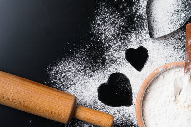 istock Baking background with flour, rolling pin and heart shape on a dark table with copy space, top view, flat lay. Valentines day cooking concept 1072052254
