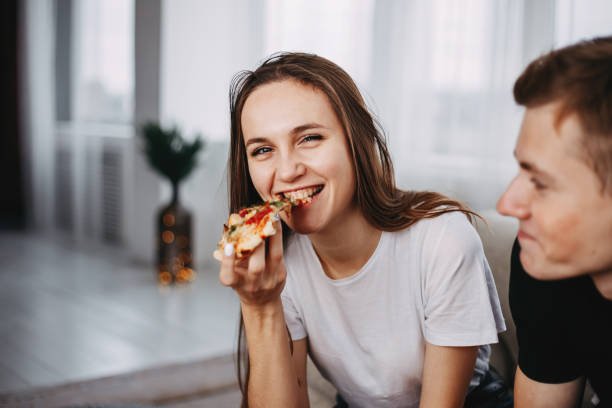 istock young attractive woman enjoy pizza, close up. 1072052436