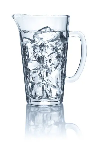 Pitcher with water and ice cubes on a white background