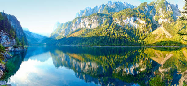 istock panorama, rocks with a forest reflecting in the water 1072061560