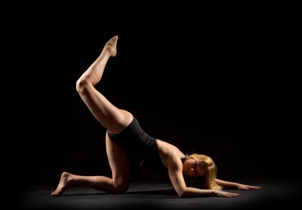 istock Woman performs pole dance on the stage. Girl whirls around the pole while performing dance or yoga  in the studio. Blonde lady dancing a striptease 1072067170