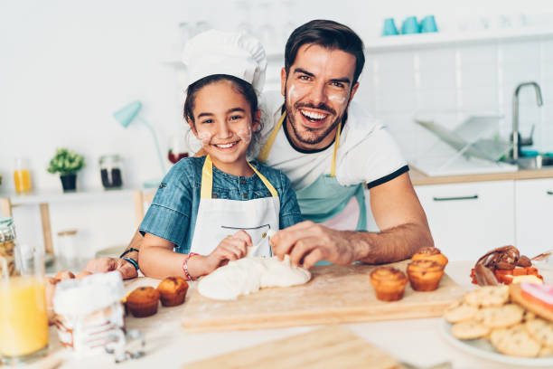 istock Cheerful and messy father and daughter in the kitchen 1072070576