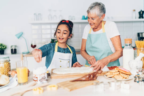 cocinar juntos - grandmother generation gap senior adult granddaughter fotografías e imágenes de stock