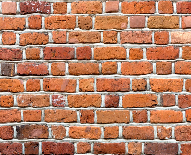 istock Close-up of natural old vintage weathered red brown not plastered solid brick wall. Abstract copy space background, Bricklaying, construction and masonry concept. 1072071404