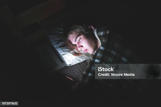 Depressed Teenager On His Phone In The Dark Stock Photo - Download Image Now - Teenager, Sleeping, Telephone