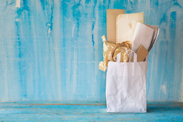 One closed paper bag on light green background. Space for text