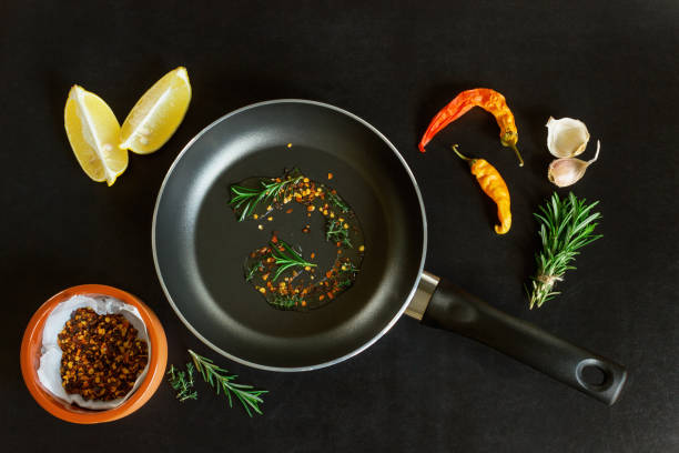 istock Frying pan with spices on a black background. Concept- cooking, menu, recipes. 1072074742