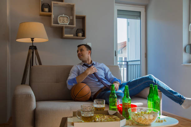 Group of mid adult males watching basketball game after work stock photo