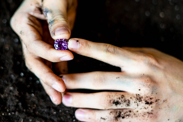 istock searcher hands holding a diamond in the soil ground f 1072079248