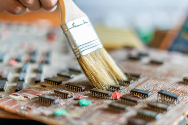 istock engineer removes dirty dust from the computer board using a brush f 1072081362