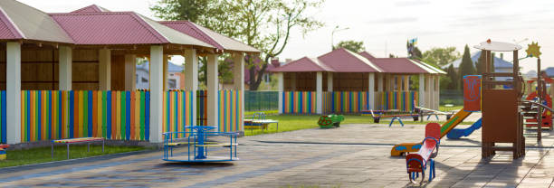 istock Beautiful new modern playground in kindergarten with soft pavement, bright new multicolored alcoves, swings, slides, benches, roundabout and sandbox. Perfect place for children activities outdoors. 1072083732