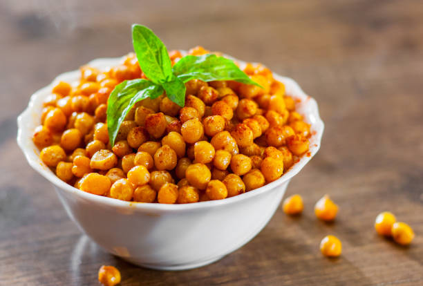istock Fried spicy chickpeas in white bowl on wooden table background 1072084796