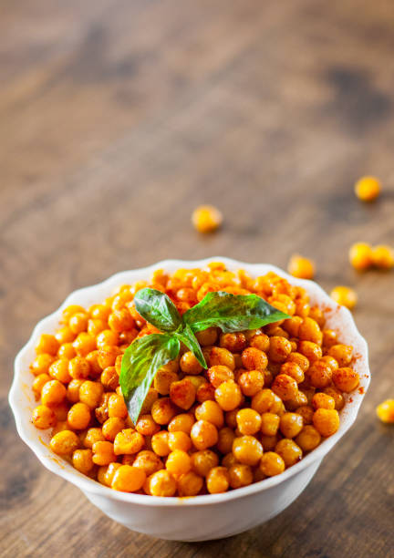 istock Fried spicy chickpeas in white bowl on wooden table background 1072084810