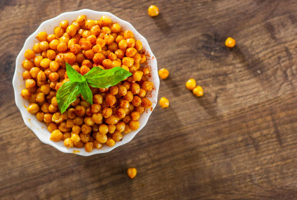istock Fried spicy chickpeas in white bowl on wooden table background 1072084870