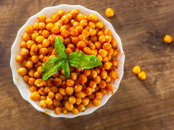 istock Fried spicy chickpeas in white bowl on wooden table background 1072085084