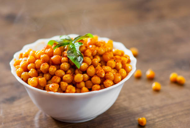 istock Fried spicy chickpeas in white bowl on wooden table background 1072085350