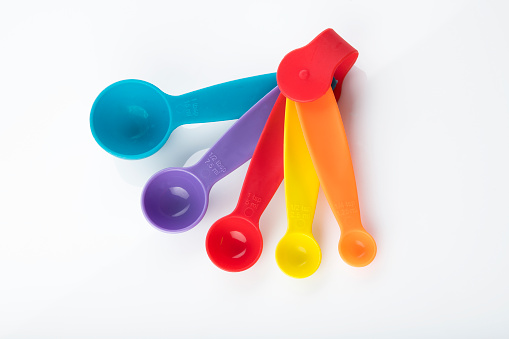 High resolution image of multi colored measuring spoon on white background shot in studio