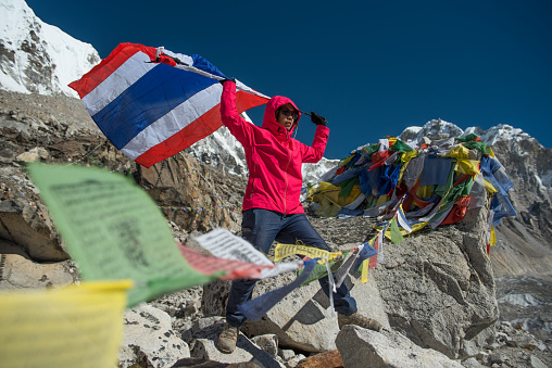 Asian lady trekker with Thai flag summit everest base camp ,nepal.travel concept
