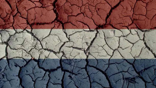 Political Crisis Or Environmental Concept: Mud Cracks With Netherlands Flag