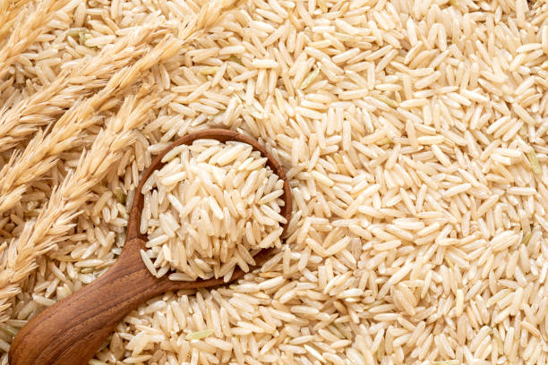 istock Brown rice in  wooden spoon on rice seed background 1072088404