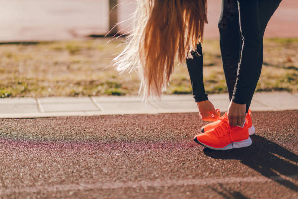 istock Female race runner tying shoelaces 1072089438