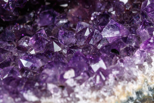 istock Macro Mineral Stone Amethysts in the rock on a white background 1072090896