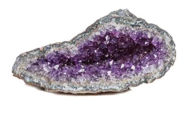 Macro Mineral Stone Amethysts in the rock on a white background close up