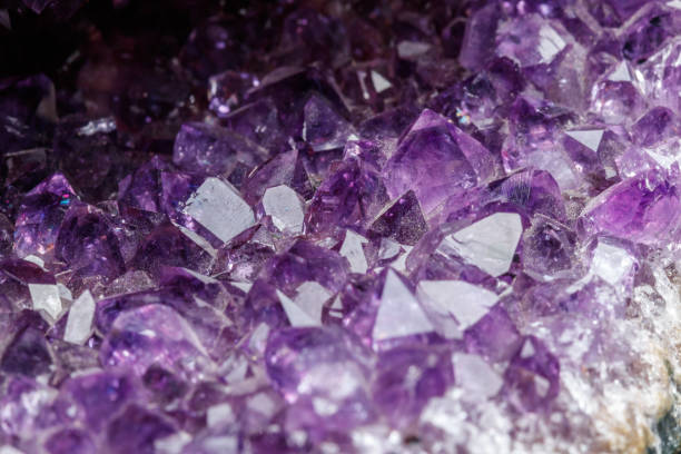 istock Macro Mineral Stone Amethysts in the rock on a white background 1072092468