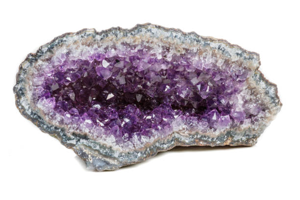 istock Macro Mineral Stone Amethysts in the rock on a white background 1072092512