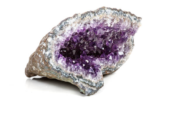istock Macro Mineral Stone Amethysts in the rock on a white background 1072092654